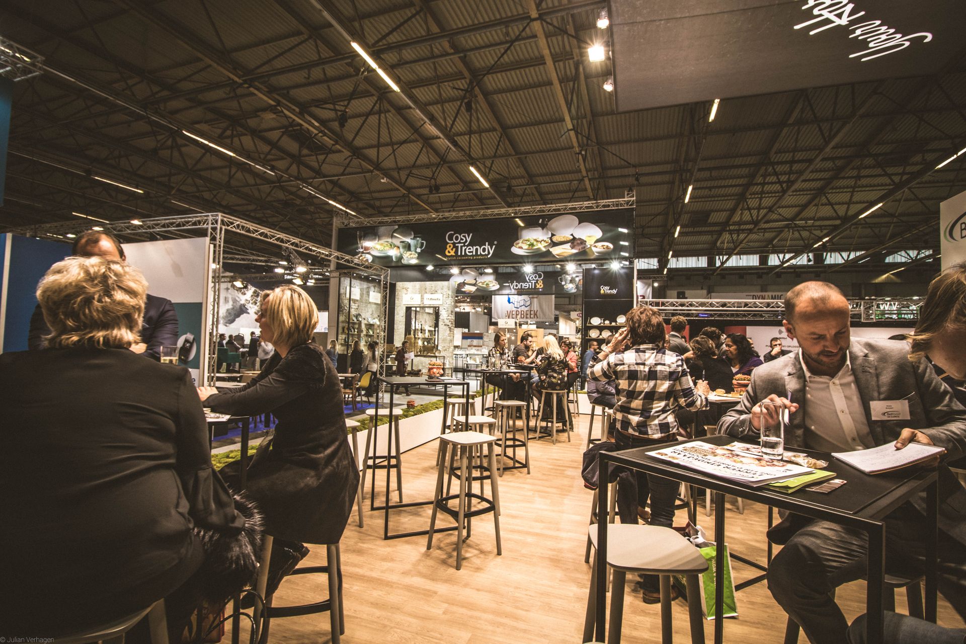 visiteurs échangeant avec des exposants devant un stand lors d'un salon professionnel