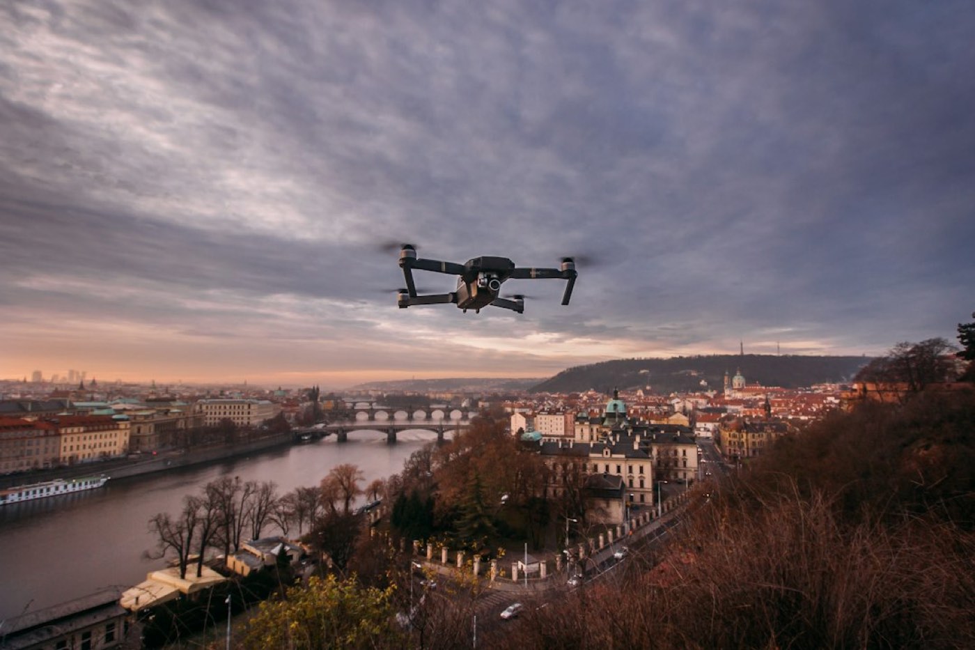 drone quadricoptère noir volant au-dessus de la colline en journée