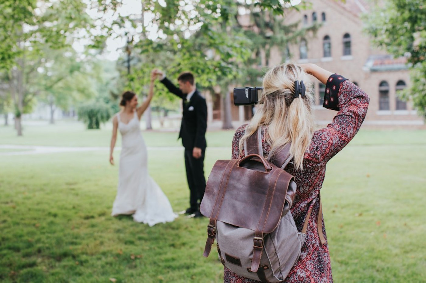 Couple lors d'une séance avant mariage en extérieur, photographe au travail en contre‑jour, visages non reconnaissables