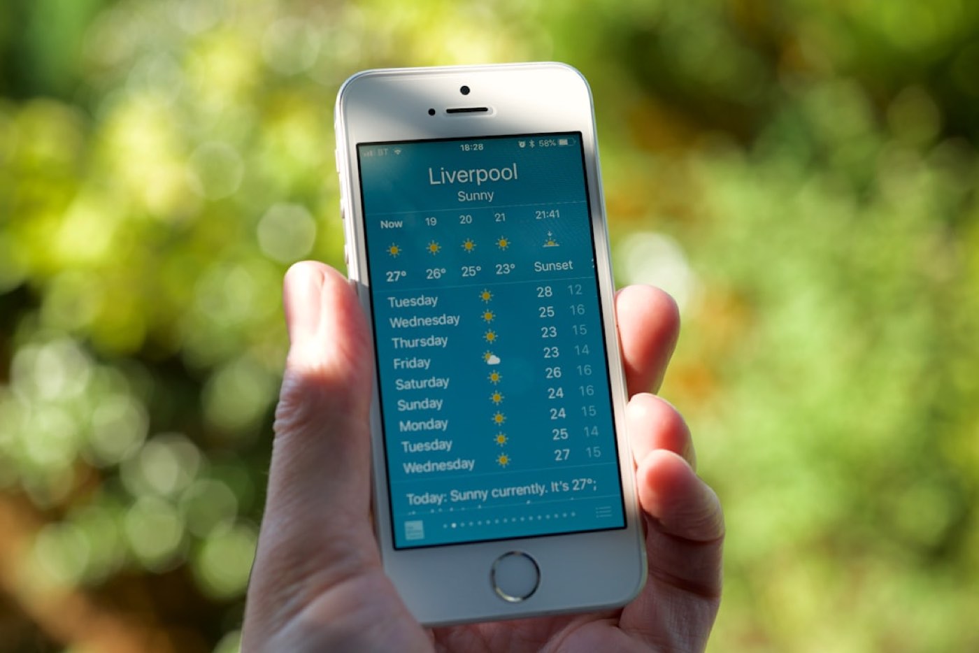 Personne tenant un iPhone 5s argent allumé affichant Liverpool