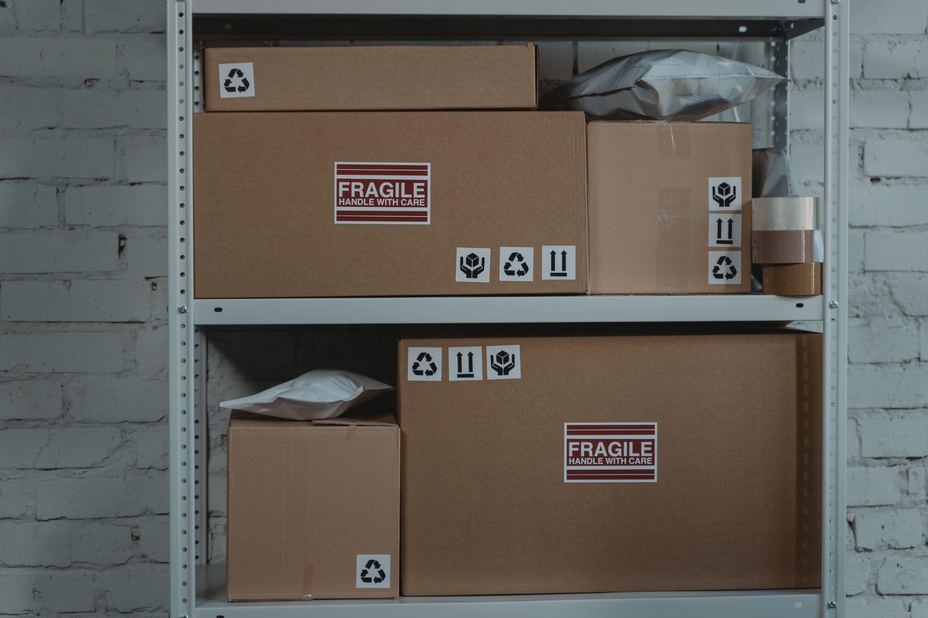 cartons marqués fragile rangés sur un rayonnage métallique dans une réserve
