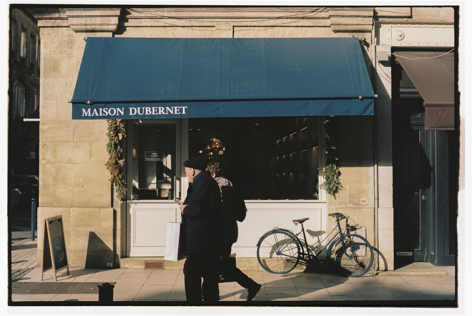 Rue commerçante à Bordeaux avec vitrines et signalétique urbaine